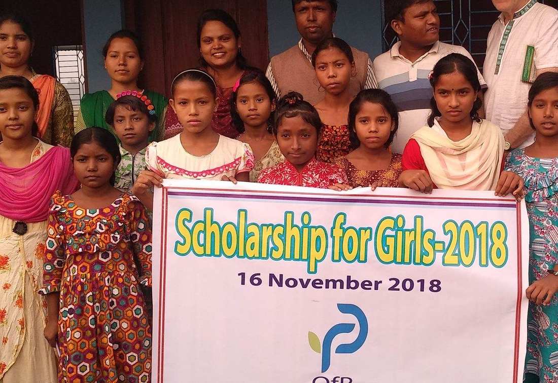 Girls holding an OfP Scholarship for Girls 2018 banner with OfP staff and supporters