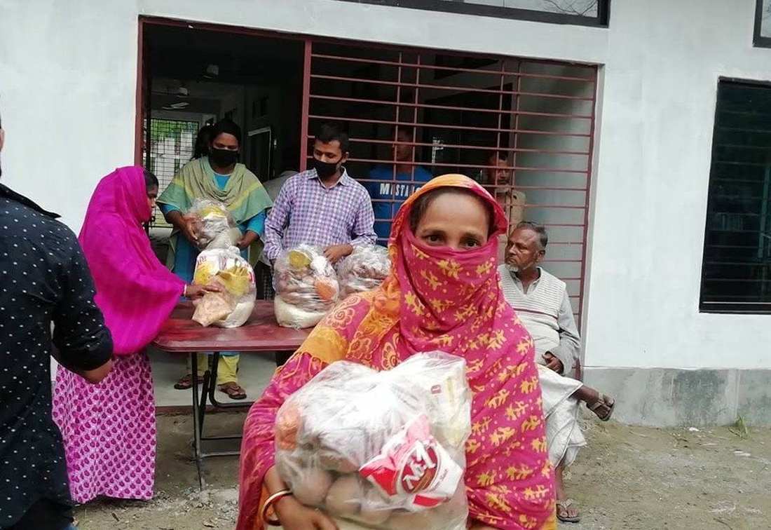 A woman holding a relief food package at an OfP distribution point